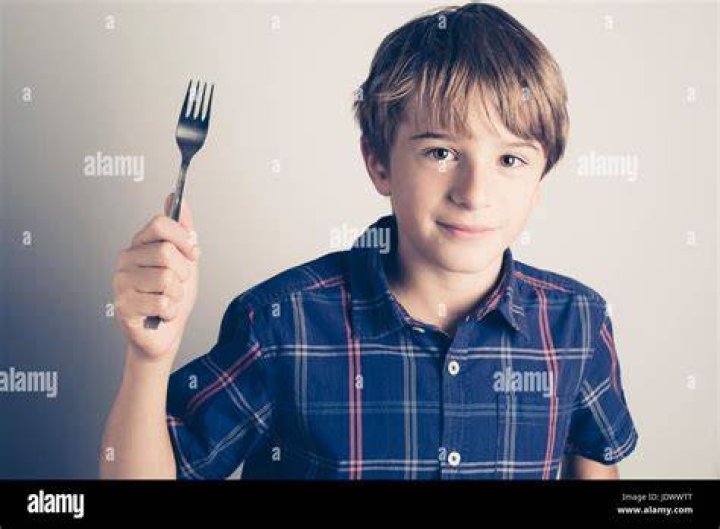little boy with fork ready to eat filtered retro style Stock Photo